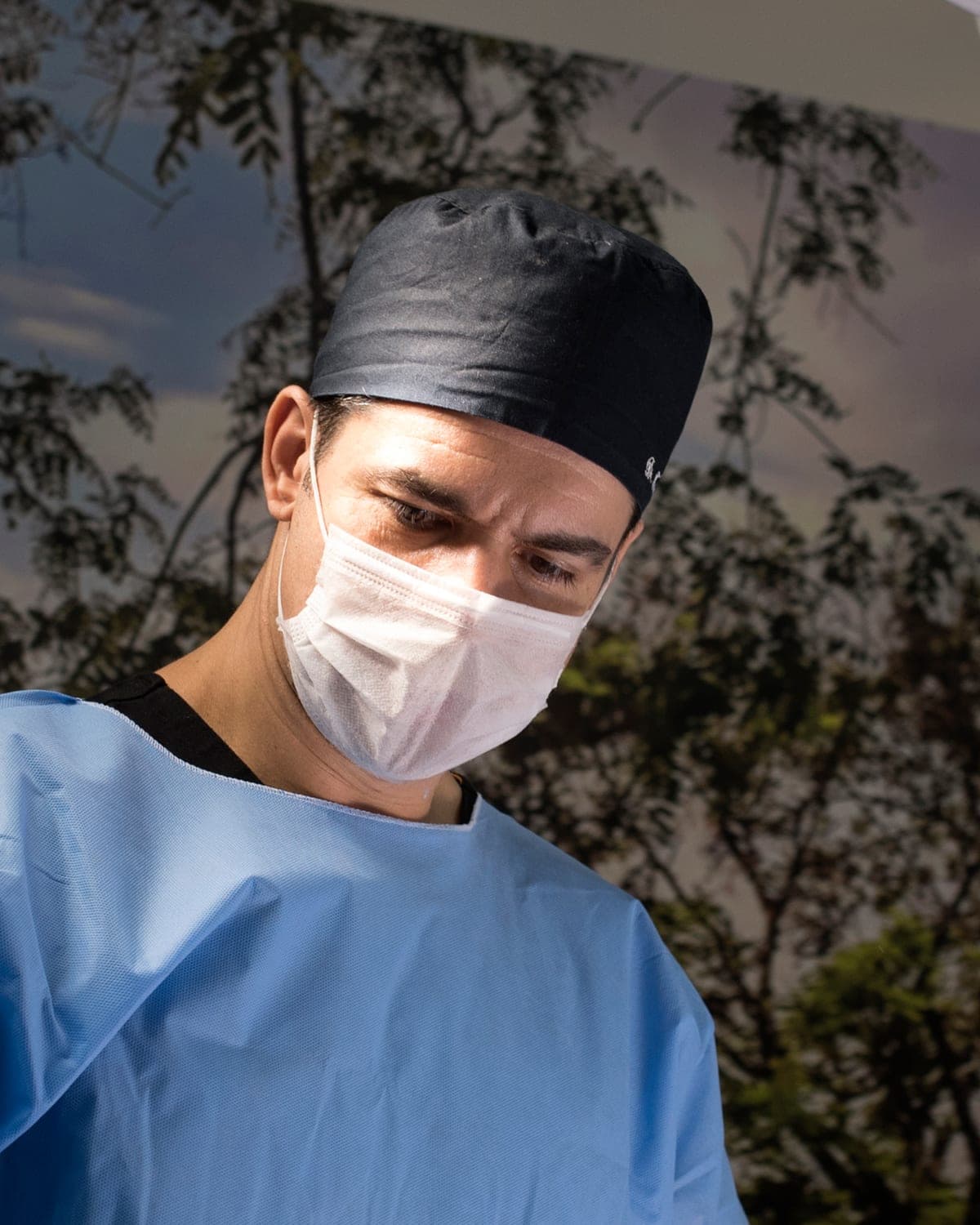 Dr. Fernando Thomazinho em cirurgia, de touca e máscara